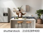 Small photo of Happy joyful African dancer girl listening to music, dancing while preparing dinner in home kitchen, having fun at cooking island table with cut vegetables, healthy organic food ingredients