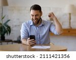Happy excited smartphone user enjoying win, success, achieve, high job result. Euphoric businessman using cellphone, reading text message, feeling joy, making hand winner gesture, laughing