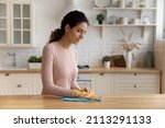 Small photo of Housewife standing in modern cozy kitchen wear protective glove wipes wood dining table surface with microfiber rag, use professional cleaning products for home perfect tidiness, housekeeping concept