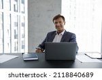 Small photo of Happy mature businessman, company executive, CEO head shot portrait. Male business leader, professional, project owner sitting at work desk, laptop computer, looking at camera, smiling