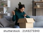 Small photo of Awful service. Angry latin female shopper hold opened box call delivery company to complain on getting wrong order. Young lady client writing feedback on shop website dissatisfied with product quality