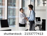 Small photo of Two diverse confident business man and woman shaking hands in office meeting room. Employer hiring candidate after job interview. Client greeting manager, lawyer with handshake. Negotiation concept