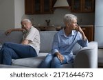 Small photo of Thoughtful older married couple sit on sofa separately, feeling frustrated looking upset after quarrel. Misunderstanding between mature spouses, crisis in relationships, difficulties, jealousy concept