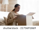 Small photo of That is awful. Concerned annoyed millennial woman client customer of internet shop delivery service receiving broken defective goods feeling bad nervous thinking about complaint demanding money refund
