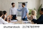 Small photo of Young Caucasian businessman introduce new male employee or worker at group meeting in office. Man boss or director welcome newcomer newbie at workplace. Colleagues applaud. Recruitment concept.