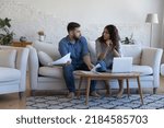 Small photo of Annoyed worried married couple of homeowners, renters arguing about financial problems, discussing expenses, insurance, mortgage, rental fees, bankruptcy, eviction, overspent budget