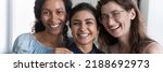 Small photo of Horizontal photo three laughing multiracial women cropped close up portrait. Faces of attractive African, Indian, Caucasian girlfriends smile look at camera. Amity, friendship, racial equality