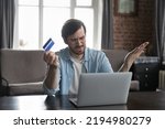 Small photo of Annoyed frustrated bank customer man using laptop, reading message, notice about problem with credit card, blocked account, counting expenses, loss, getting financial overspending, bankruptcy