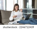 Excited woman sits on sofa hold sheet, get formal document, official agreement, read paper notice feels happy. Student pass exam, celebrate university admission, scholarship or bank loan approval