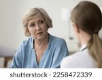 Serious older patient woman visiting doctor, getting geriatric health problems after medical checkup, listening to practitioner explaining diagnosis, giving treatment, therapy recommendation