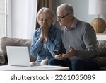 Small photo of Shocked upset elderly couple getting bad news, finding fraud, money stealing, loss, overspending, financial problem, holding calculator, using laptop, staring at monitor
