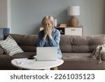 Small photo of Shocked concerned senior accountant woman finding financial failure, mistake, bankruptcy, sitting at laptop, calculator, paper bills, covering face in panic attack, staring at screen