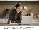 Small photo of Cheerful smart online student girl watching learning video, webinar, writing summary for essay, article, research study, using Internet communication for education at home