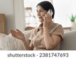 Small photo of Mature woman blab on cellphone seated on cozy couch at home, talking using modern smartphone lead pleasant, personal conversation to family or friend, use e-services making order. Tech, communication