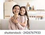 Small photo of Beautiful multigenerational family ties, bond, harmonic relationships. Cute little 5s granddaughter and pretty mature granny hugging, laughing, looking at camera, feel love, showing support and care