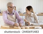 Small photo of Grandpa teach preteen granddaughter prepare pastries, blab, kneading dough, sit at table making homemade, family recipe buns, enjoy pleasant friendly conversation, cooking sweets on weekend at home