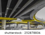 Under a concrete road bridge with yellow pillars