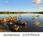 Small photo of Small boat moored next to a precarious wooden pier with the silhouette of the city of Aracaju in the background