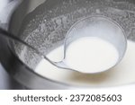 Small photo of Pancake batter background. Mixing ingredients. Metal bowl with liquid dough. Metal ladle for pancakes. Breakfast frying. Flour, eggs and milk recipe. Raw batter ready to fry.
