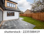 Small photo of Cook Close, Cambridge, England - October 16 2018: Vacant new house simple landscaped garden primarily laid to lawn with damp patio and bifold doors