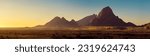 Wide panorama of a stone desert at sunrise in haze  of soft sunlight, mountain landscape of Spitzkoppe hills, Namibia. Travel to wildlife of Africa, extreme tour, adventures to wilderness. 