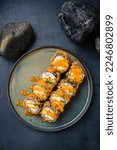Small photo of Hot fried Sushi Roll with salmon, eel and cheese. Sushi menu. Japanese food. Hot fried Sushi Roll. Hot sushi rolls with salmon, eel and Philadelphia cheese and sauce. Top view.