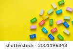 Small photo of Multicolored cubes from the syllables of the Russian language on a yellow background. The concept of teaching reading