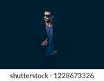 Small photo of Portrait of nice lovely self-content handsome attractive classy elegant man in blazer sunglasses holding hand in pocket looking aside isolated over dark black background