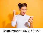 Small photo of Portrait of delighted thrilled excited screaming lady impressed by news feed in her social network account rasing fists isolated on vibrant background in white clothing