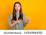 Small photo of Photo of shocked disquieted girl dissatisfied with her new phone while isolated with vivid yellow background