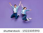 Full body photo of funny funky crazy cheerful married students with brown hair redhair jump have relax spring holidays date raise hands wear youth clothes isolated over purple color background