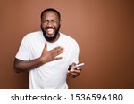 Portrait of his he nice attractive cheerful cheery bearded guy wearing white tshirt reading hilarious funny smm post blog story laughing isolated over dark brown pastel color background