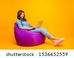 Small photo of Full length body size turned photo of cheerful positive cute nice attractive blogger browsing through her laptop in search of new information isolated over yellow vibrant color background
