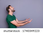 Profile photo of attractive amazed handsome guy good mood raise arms up side empty space waiting novelty product falling catch wear casual green t-shirt isolated grey color background