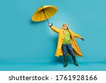 Small photo of Full length body size view of his he cheerful cheery dreamy grey-haired man wearing yellow topcoat bad cold weather cyclone day isolated over bright vivid shine vibrant blue color background