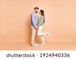 Small photo of Full length body size profile side view of nice amorous couple soulmates meet holding hands isolated on beige pastel color background