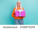 Photo of nice happy old woman hold present holiday gift good mood isolated on pastel teal color background