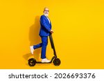 Full length body size profile side view of nice cheerful chic man riding scooter having fun isolated over bright yellow color background