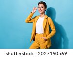 Portrait of attractive cheerful skilled woman expert posing touching specs isolated over bright blue color background
