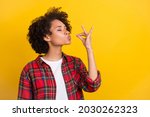 Portrait of attractive dreamy cheerful girl tasting invisible meal dish isolated over bright yellow color background