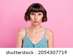 Small photo of Portrait of attractive amorous brown-haired girl sending air kiss isolated over pink pastel color background