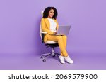 Photo of  cute woman dressed yellow suit spectacles sitting chair typing modern device isolated violet color background