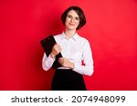 Photo of happy positive lovely charming secretary in glasses hold organizer smiling isolated on red color background