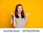 Photo of young happy positive excited crazy winner girl screaming with closed eyes isolated on yellow color background