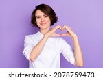 Portrait of attractive cheerful girl showing heart shape amour affection isolated over bright violet purple color background