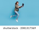 Full body profile side photo of computer nerd lady jump use device chatting wear shirt denim jeans isolated over blue color background