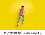 Small photo of Full length back photo of brunet millennial guy run away wear red t-shirt jeans shoes isolated on yellow background