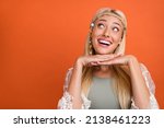 Portrait of attractive cheerful amazed blond girl creating solution copy space isolated over bright orange color background