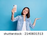 Photo of shiny cute lady dressed denim shirt tacking selfie gadget arm empty space isolated blue color background