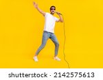 Small photo of Full length photo of nice millennial brunet guy sing wear eyewear t-shirt jeans sneakers isolated on yellow background